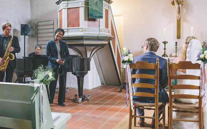 Sängerin singt für ein Brautpaar während der Trauung in der Kirche