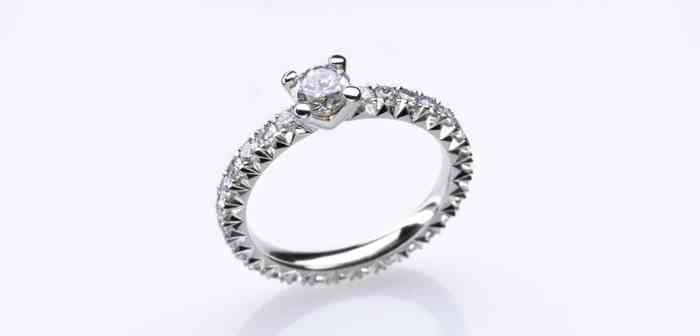 Verlobungsring mit einem großen Diamanten in der Mitte und kleinen Brillanten als Rahmen.