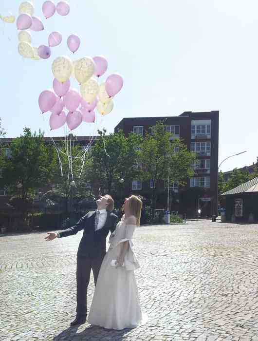 Brautpaar mit Luftballonen.