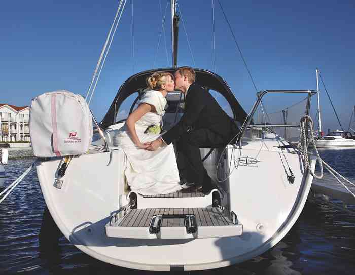 Brautpaar küsst sich auf Segelboot. Marina Iberhotel Boltenhagen. 