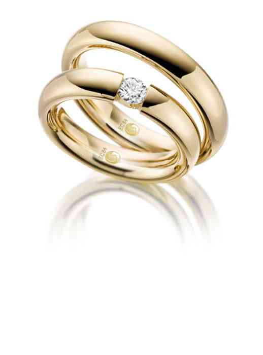 Edle Trauringe aus klassischem Gelbgold. Der Ring der Braut ist mit einem großen Diamanten besetzt. 