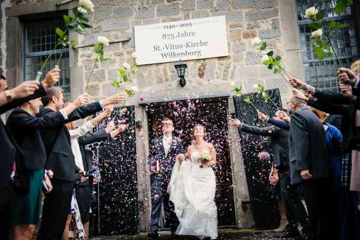 Brautpaar läuft durch Blütenkonfetti
