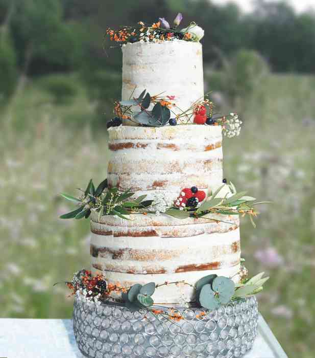 Eine bezaubernder Naked Cake im klassischen Stil mit Beeren und einigen Blüten als Highlight. Kaum ein Tortenstil schafft es so schön, eine edle Anmutung mit einer natürlichen leichten Optik zu verbinden.