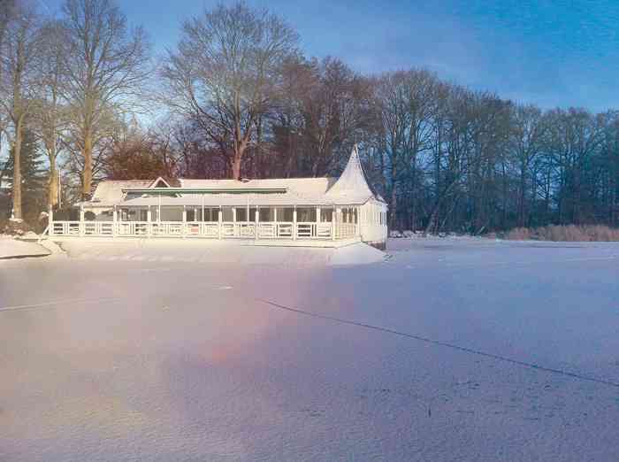 Hochzeitslocation Bokel-Mühle am See mit zugeschneitem Mühlensee.  Bokeler See mit Seepavillon im Winter