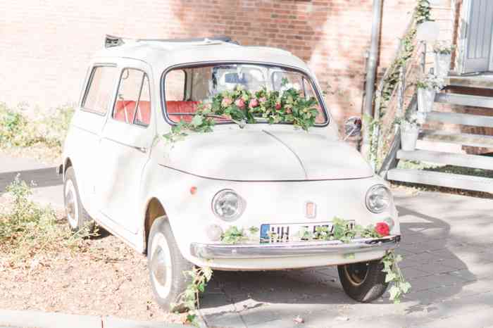 Hochzeitsauto mit Rosenschmuck vor den Türen der Hase liebt Igel Hochzeitsmesse.