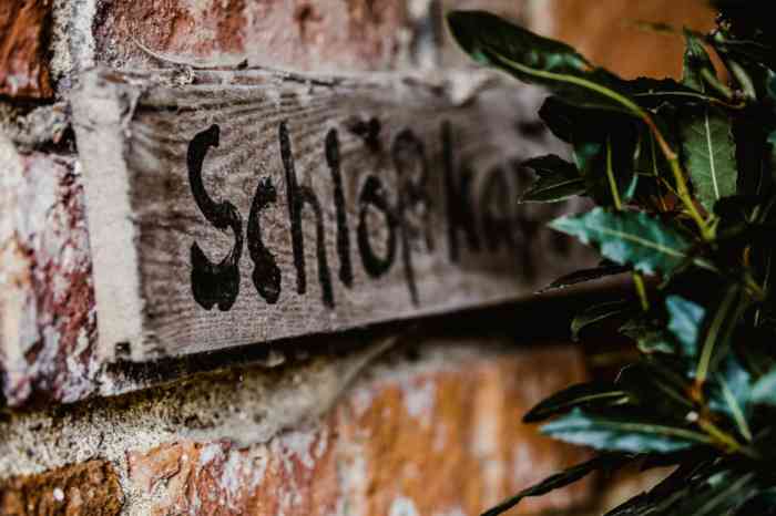Ein schönes Holzschild begrüßt die Hochzeitsgesellschaft auf Schloss Neuenhausen. Holzschild mit dem Schriftzug Schloß Neuenhausen.