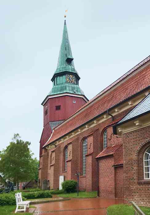 In der Hochzeitskirche in Steinkirchen können Hochzeitspaare sich trauen lassen. Eingang der Kirche Sankt Martini et Nicolai zu Steinkirchen mit hölzernem Glockenturm.