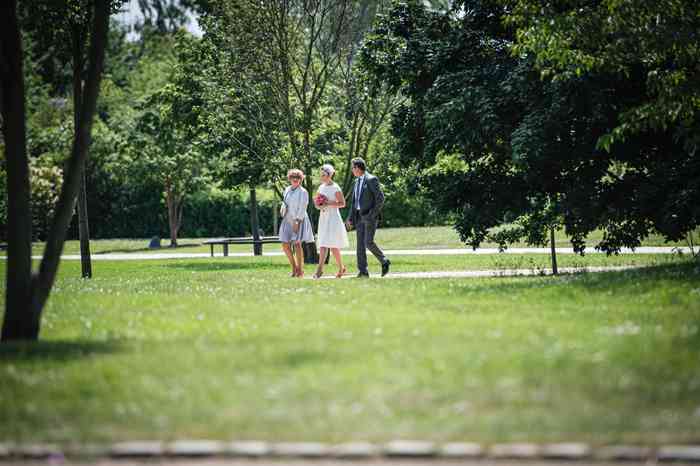 Braut mit Eltern schreitet durch den Park der Sinne in Laatzen.